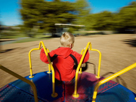 a child playing on a merry go round