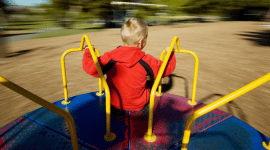 a child playing on a merry go round