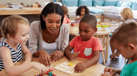 A educator working with young children in early classroom