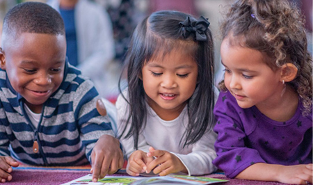 Preschool children reading a book